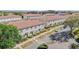 View of townhomes with barrel tile roofing, green lawns, and mature trees create a welcoming atmosphere at 3127 Via Otero Dr, Kissimmee, FL 34744