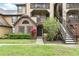Charming condo exterior featuring brick accents, landscaped grounds, and convenient stairwell access to upper units at 320 Black Oak Ct # 102, Altamonte Springs, FL 32701