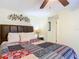 Cozy bedroom featuring a decorative wall hanging, bedside table with lamp, and a colorful patterned quilt on the bed at 322 And 322 1/2 S Maple Ave, Sanford, FL 32771