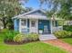 Charming cottage-style home with blue exterior and a welcoming porch, complemented by lush greenery at 322 And 322 1/2 S Maple Ave, Sanford, FL 32771