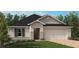 Charming single-story home featuring a brick driveway, manicured lawn, and an attached two-car garage at 3413 Sanctuary Dr, Clermont, FL 34714