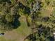 Aerial shot of a unique property featuring green space, a water retention area, and tree coverage for privacy at 372 Carpenter Ave, Osteen, FL 32764