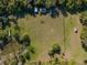 Aerial view of a sprawling green field dotted with sheds, surrounded by mature trees, offering a serene and picturesque setting at 372 Carpenter Ave, Osteen, FL 32764