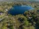 Aerial view showcasing a tranquil lake surrounded by lush greenery and various structures, reflecting a serene environment at 372 Carpenter Ave, Osteen, FL 32764