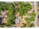 An aerial view shows the home nestled among lush trees on a spacious lot, highlighting its unique architectural design at 450 Cassady St, Umatilla, FL 32784