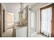 Bathroom featuring a dual sink vanity, decorative mirrors, and a walk-in shower at 450 Cassady St, Umatilla, FL 32784