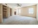 Large bedroom with natural light, ceiling fan, carpeted floor, and large closets with wooden panels at 450 Cassady St, Umatilla, FL 32784