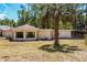 The home's exterior showcases a unique sunroom design, surrounded by a landscape featuring a mature palm tree at 450 Cassady St, Umatilla, FL 32784