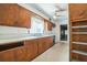 Functional kitchen with wooden cabinets, a ceiling fan, and a window above the sink at 450 Cassady St, Umatilla, FL 32784