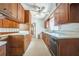 Functional kitchen with wood cabinets, laminate countertops, and adjacent hallway at 450 Cassady St, Umatilla, FL 32784