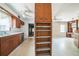 View of kitchen and office space with built in shelving, cabinets, and vintage wallpaper at 450 Cassady St, Umatilla, FL 32784