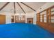 Spacious living room with vaulted ceilings, exposed beams, blue carpet, and built-in cabinets at 450 Cassady St, Umatilla, FL 32784
