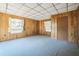 Living room featuring wood paneled walls, carpet flooring, and two windows for natural light at 450 Cassady St, Umatilla, FL 32784