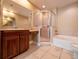 Bathroom featuring a tiled shower, separate tub, and a vanity with wood cabinets at 4504 Messina Dr, Lake Mary, FL 32746