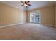 Large bedroom with carpet flooring, ceiling fan, and sliding glass doors to the balcony at 4504 Messina Dr, Lake Mary, FL 32746