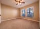 Bright bedroom featuring neutral carpet, a ceiling fan, and two large windows at 4504 Messina Dr, Lake Mary, FL 32746