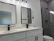 Bright bathroom featuring double vanities, black hardware, modern lighting, and a gray tiled shower at 489 Marion Oaks Golf Rd, Ocala, FL 34473