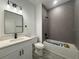 Modern bathroom featuring a white vanity with a quartz countertop and a gray tiled shower and tub at 489 Marion Oaks Golf Rd, Ocala, FL 34473