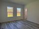 Sunlit bedroom with luxury vinyl plank flooring and two bright windows at 489 Marion Oaks Golf Rd, Ocala, FL 34473