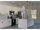 Bright kitchen with white cabinetry, stainless steel appliances, quartz countertops and modern pendant lighting at 489 Marion Oaks Golf Rd, Ocala, FL 34473