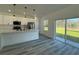 Open kitchen with white cabinetry, stainless steel appliances, and large sliding glass doors at 489 Marion Oaks Golf Rd, Ocala, FL 34473