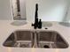 Close up of a double stainless steel sink with quartz countertop and a modern black faucet at 489 Marion Oaks Golf Rd, Ocala, FL 34473