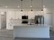 Bright kitchen featuring a large island, quartz countertops, stainless appliances and white cabinetry at 489 Marion Oaks Golf Rd, Ocala, FL 34473