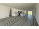 Open-concept living space with gray wood floors, white cabinets, and a center island with pendant lighting at 489 Marion Oaks Golf Rd, Ocala, FL 34473