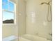 White tiled bathroom with a shower and view of the neighborhood at 5029 Southlawn Ave, Orlando, FL 32811