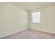 This cozy bedroom is bathed in natural light from a window with blinds and features neutral colored walls and carpet at 5029 Southlawn Ave, Orlando, FL 32811