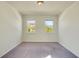 Cozy bedroom with carpet flooring, two windows with neighborhood view, and neutral paint at 5029 Southlawn Ave, Orlando, FL 32811