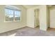 Bedroom with carpet, a large window with blinds, and a doorway to closet and bathroom at 5029 Southlawn Ave, Orlando, FL 32811