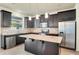 Modern kitchen with dark cabinets, granite countertops, stainless steel appliances, and island at 5029 Southlawn Ave, Orlando, FL 32811