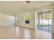 Bright open-concept living room with sliding glass doors and textured accent wall at 5029 Southlawn Ave, Orlando, FL 32811
