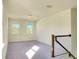 Upstairs loft area with carpet flooring, natural light, and staircase with wooden railing at 5029 Southlawn Ave, Orlando, FL 32811