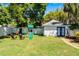 Lush backyard featuring a charming play set, an outdoor seating area, and a detached structure at 515 Clayton St, Orlando, FL 32804