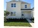 Charming two-story home features a well-maintained lawn, tidy landscaping, and a classic white exterior at 5225 Marshelder St, Apopka, FL 32712
