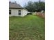 Sideyard with lush green grass and a neutral-toned exterior wall at 5342 Rabbit Ridge Trl, Orlando, FL 32818