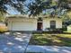 Charming single-story home with a two-car garage, red front door, and well-maintained lawn at 5342 Rabbit Ridge Trl, Orlando, FL 32818