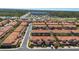 An aerial view shows a community of two-story homes with red tile roofs near a commercial area at 5373 Via Appia Way, Sanford, FL 32771