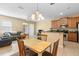 Cozy dining area adjacent to kitchen with wooden table and chairs beneath a decorative chandelier at 5373 Via Appia Way, Sanford, FL 32771