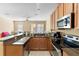 Open-concept kitchen featuring granite countertops, stainless steel appliances and breakfast bar at 5373 Via Appia Way, Sanford, FL 32771