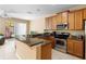 Open-concept kitchen featuring granite countertops, stainless steel appliances, and breakfast bar at 5373 Via Appia Way, Sanford, FL 32771