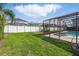 A backyard with a screened-in pool and privacy fence, perfect for enjoying outdoor activities at 548 Burford Cir, Davenport, FL 33896