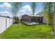 A backyard featuring a screened-in pool and lush greenery, creating a private oasis at 548 Burford Cir, Davenport, FL 33896