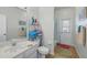 Bathroom with single sink, tile floor, open storage rack, and shower with partial curtain at 548 Burford Cir, Davenport, FL 33896
