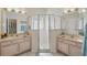 Bright bathroom featuring double sinks, framed mirrors, and glass-enclosed shower at 548 Burford Cir, Davenport, FL 33896