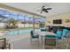 Screened-in patio with table and chairs, grill, TV, and view of the backyard pool at 548 Burford Cir, Davenport, FL 33896