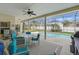 Screened-in patio with table, chairs, grill, and view of the pool and backyard at 548 Burford Cir, Davenport, FL 33896