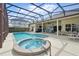 A screened-in pool area featuring a pool, spa, and covered patio with ample seating space at 548 Burford Cir, Davenport, FL 33896